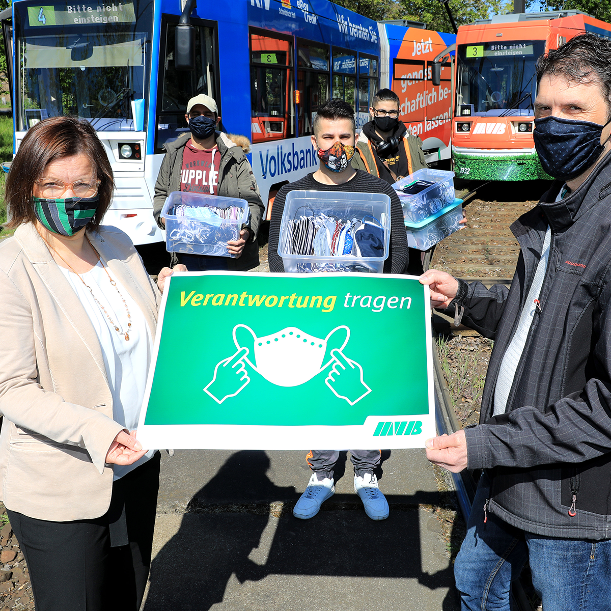 Birgit Münster-Rendel mit Christian Söder (rechts) und den Geflüchteten, die die Masken hergestellt haben. (Foto: Peter Gercke)