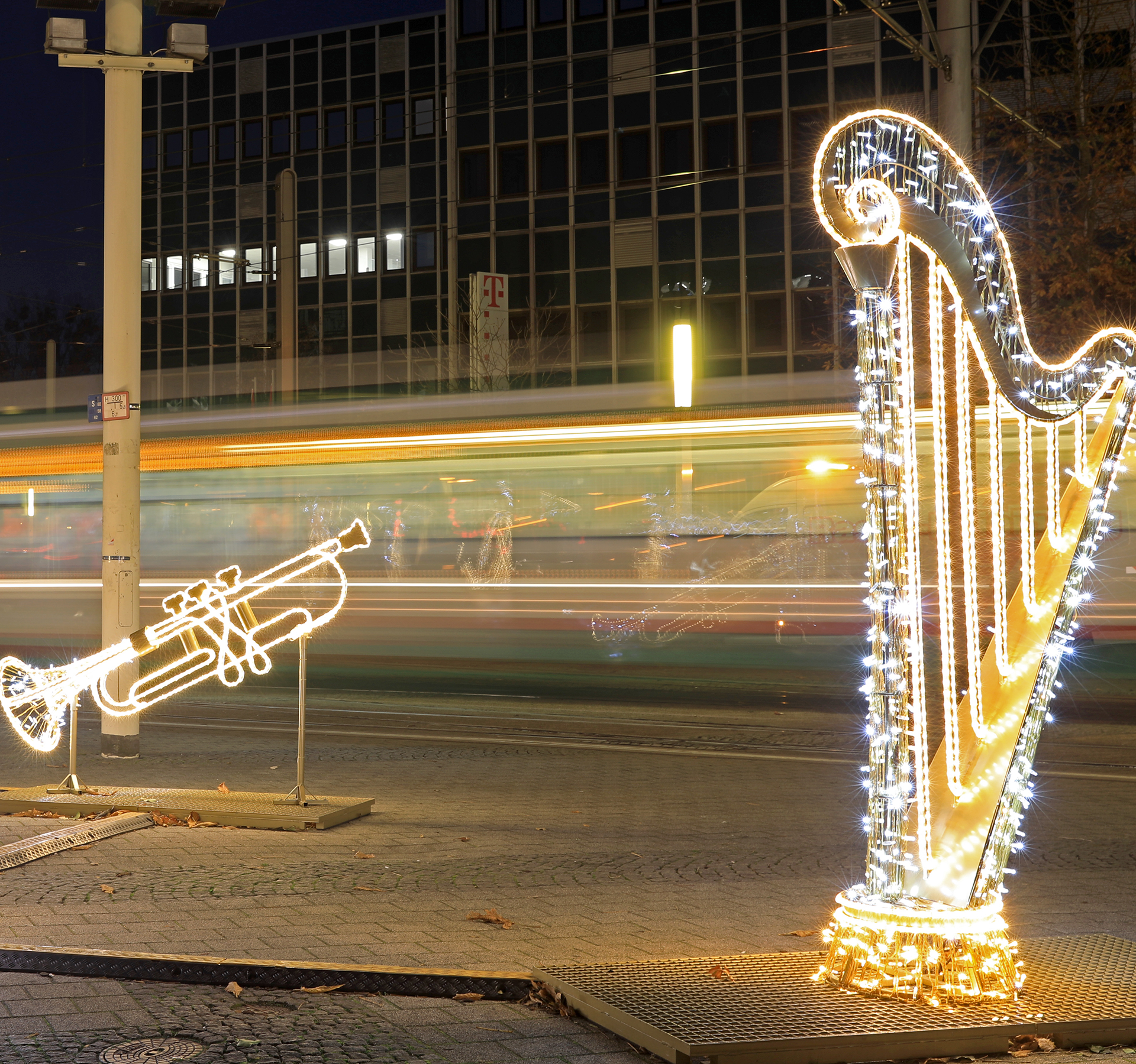 Lichterwelteninstallation vor dem Opernhaus mit einer bewegungsunscharfen Straßenbahn im Hintergrund