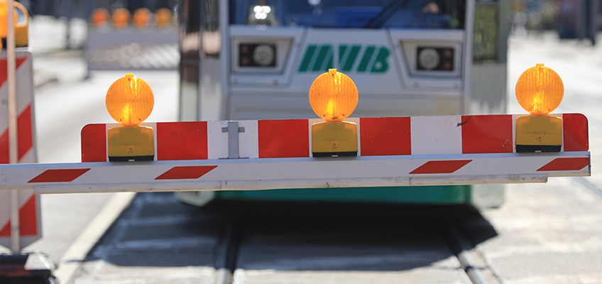 Baustellenschranke, hinter der eine Straßenbahn steht