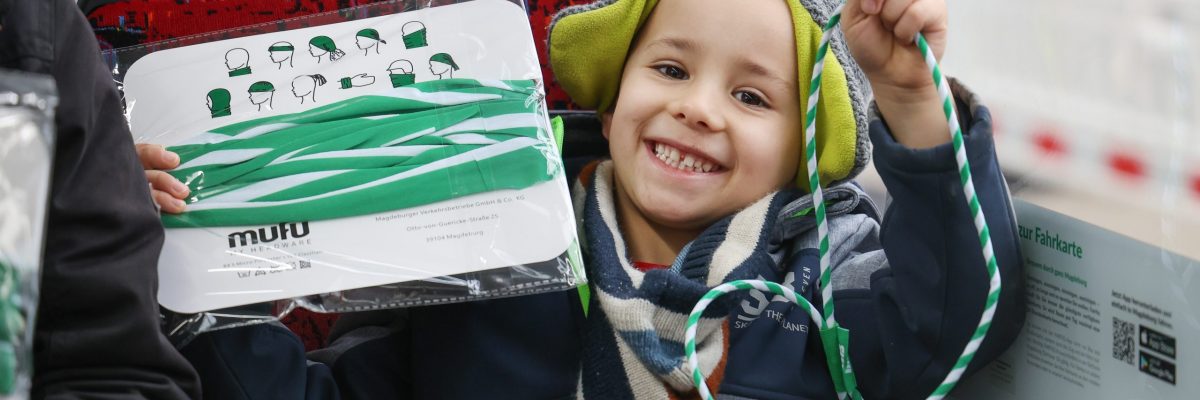 Kind hat ein Halstuch und ein Schlüsselband der MVB in der Hand
