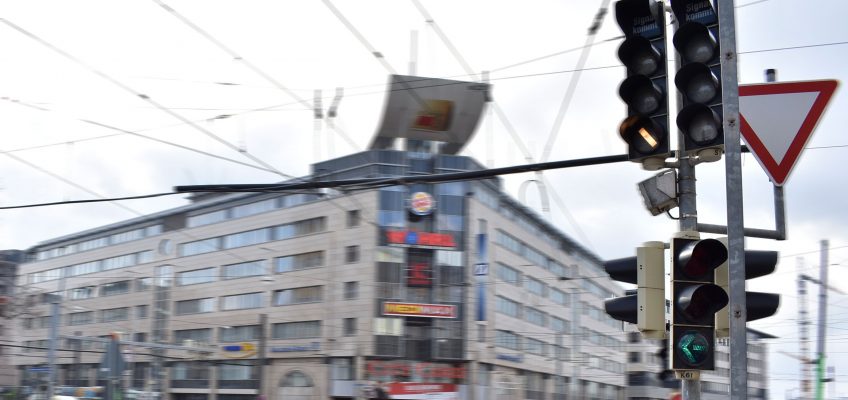 Unscharfe Aufnahme der Linksabbiegerampel und dem City Carré im Hintergrund.
