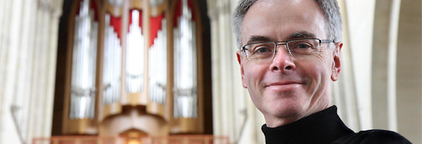 Domkantor Barry Jordan mit der Domorgel im Hintergrund.