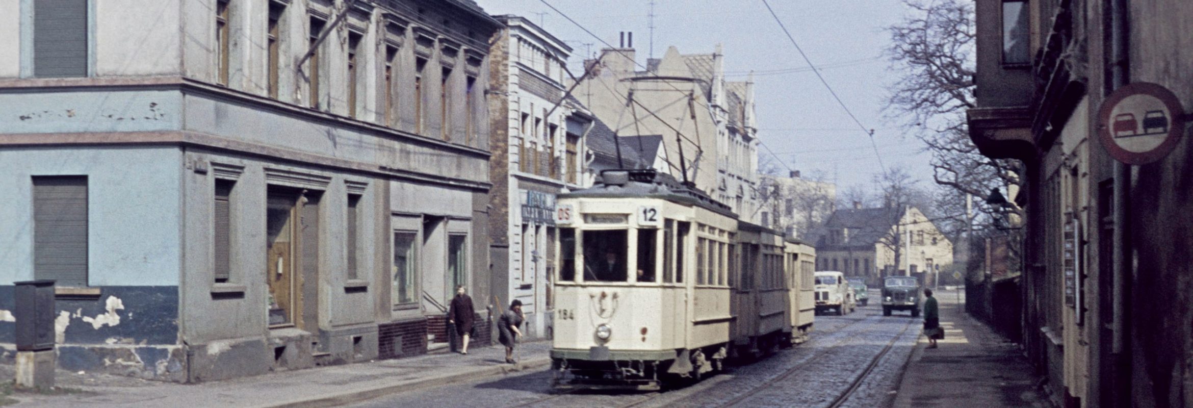 Altes Dia Bild einer Straßenbahn in einem sehr veralteten Stadtgebiet.