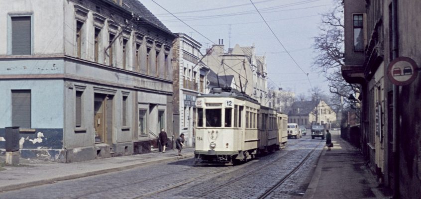 Altes Dia Bild einer Straßenbahn in einem sehr veralteten Stadtgebiet.