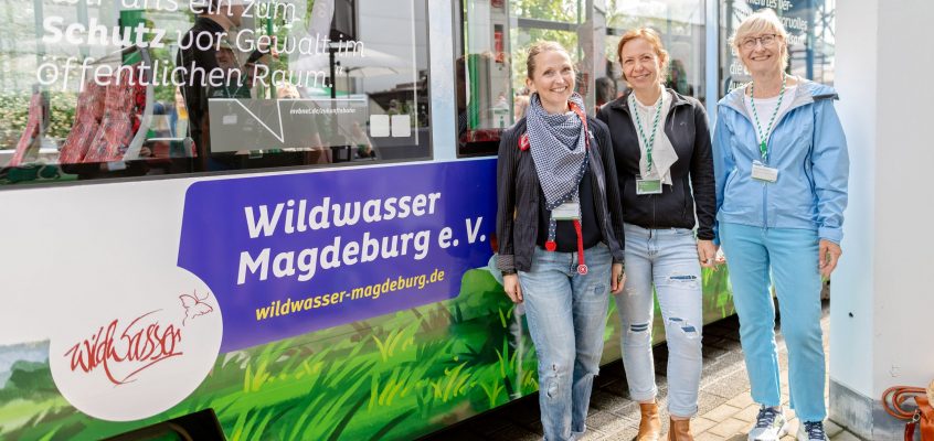Vertreterinnen des Wildwasser Magdeburg e.V. vor der mit Vereinen bedruckten Zukunftsbahn mit dem gleichnamigen Schriftzug