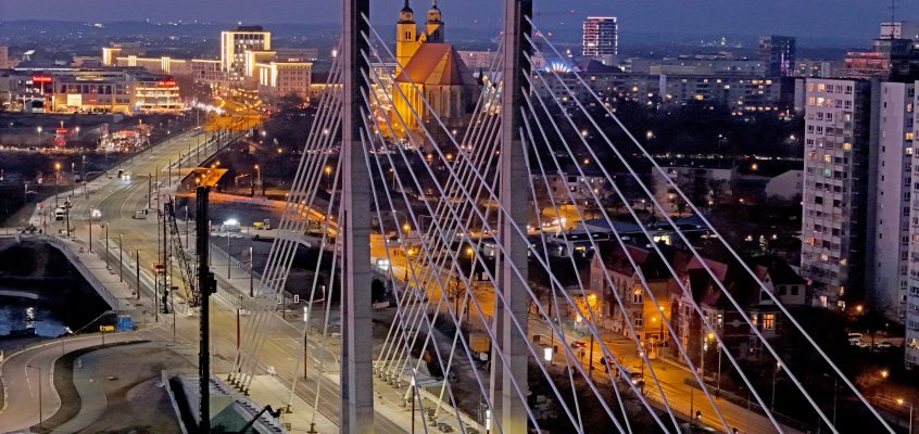 Blick über die neue Pylonenbrücke auf die Joanneskirche in der Abenddämmerung.