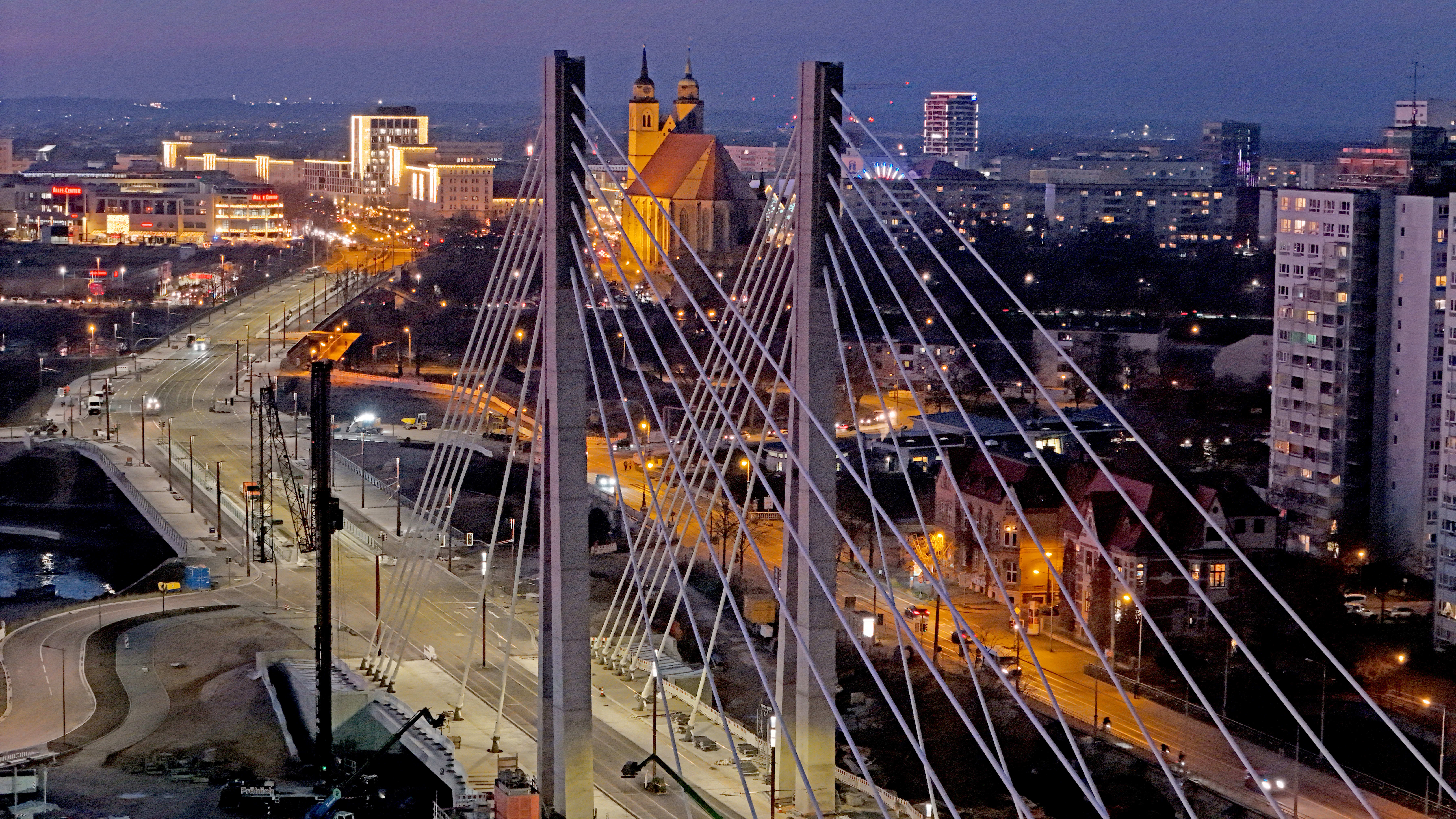 Blick über die neue Pylonenbrücke auf die Joanneskirche in der Abenddämmerung.
