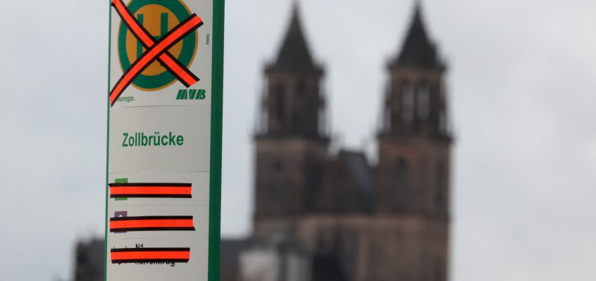 Durchgestrichenes Haltestellenschild Zollbrücke mit dem Dom im Hintergrund