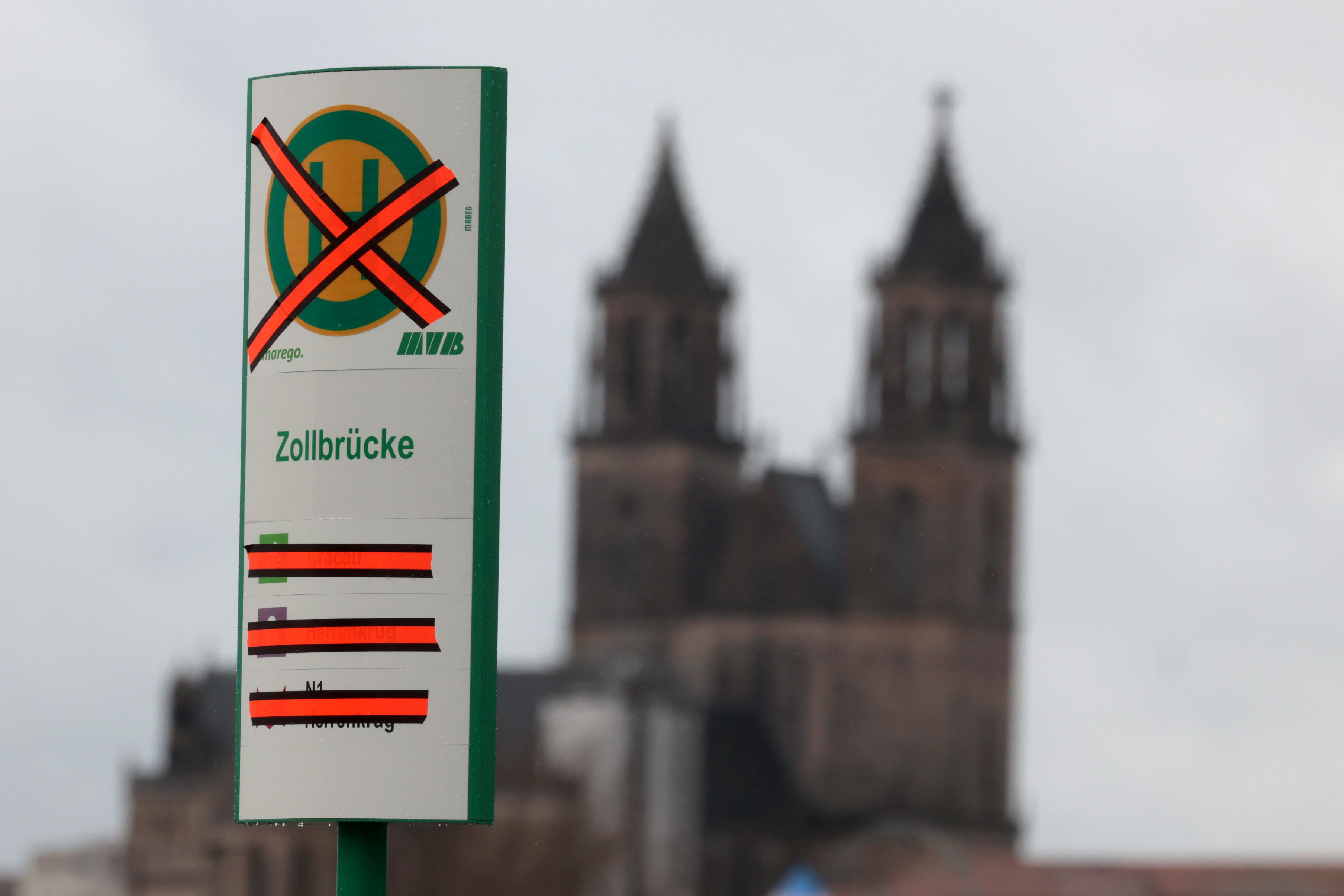 Durchgestrichenes Haltestellenschild Zollbrücke mit dem Dom im Hintergrund