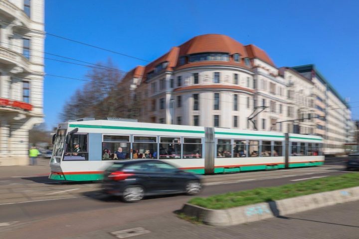 Bewegungsunscharfe Aufnahme einer Straßenbahn im Straßenverkehr.