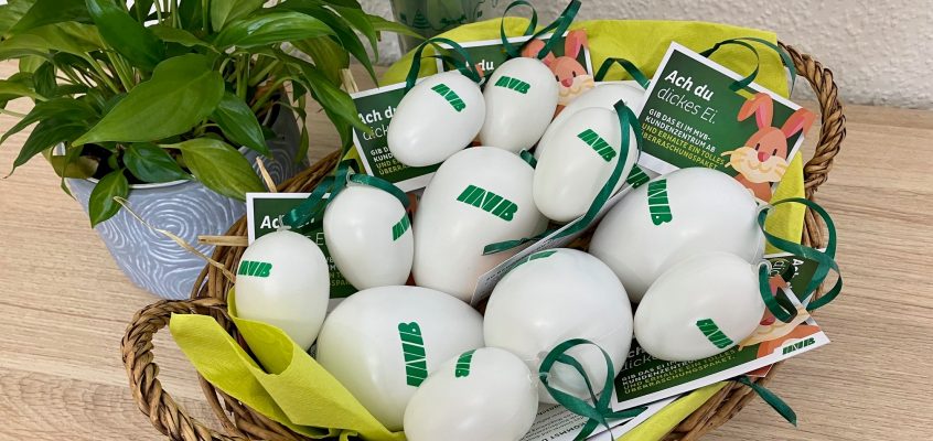 geflochtener Korb mit weißen Plastikostereiern, bedruckt mit dem MVB Logo. IM Korb liegen noch kleine Schilder mit der Aufschrift : Ach du dickes Ei.