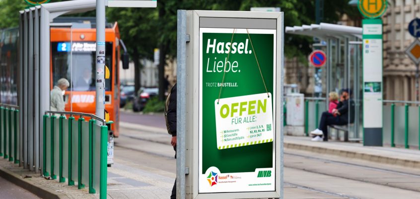 Werbetafel der MVB an der Haltestelle Hasselbachplatz mit der Aufschrift: Hassel.Liebe. Offen für alle