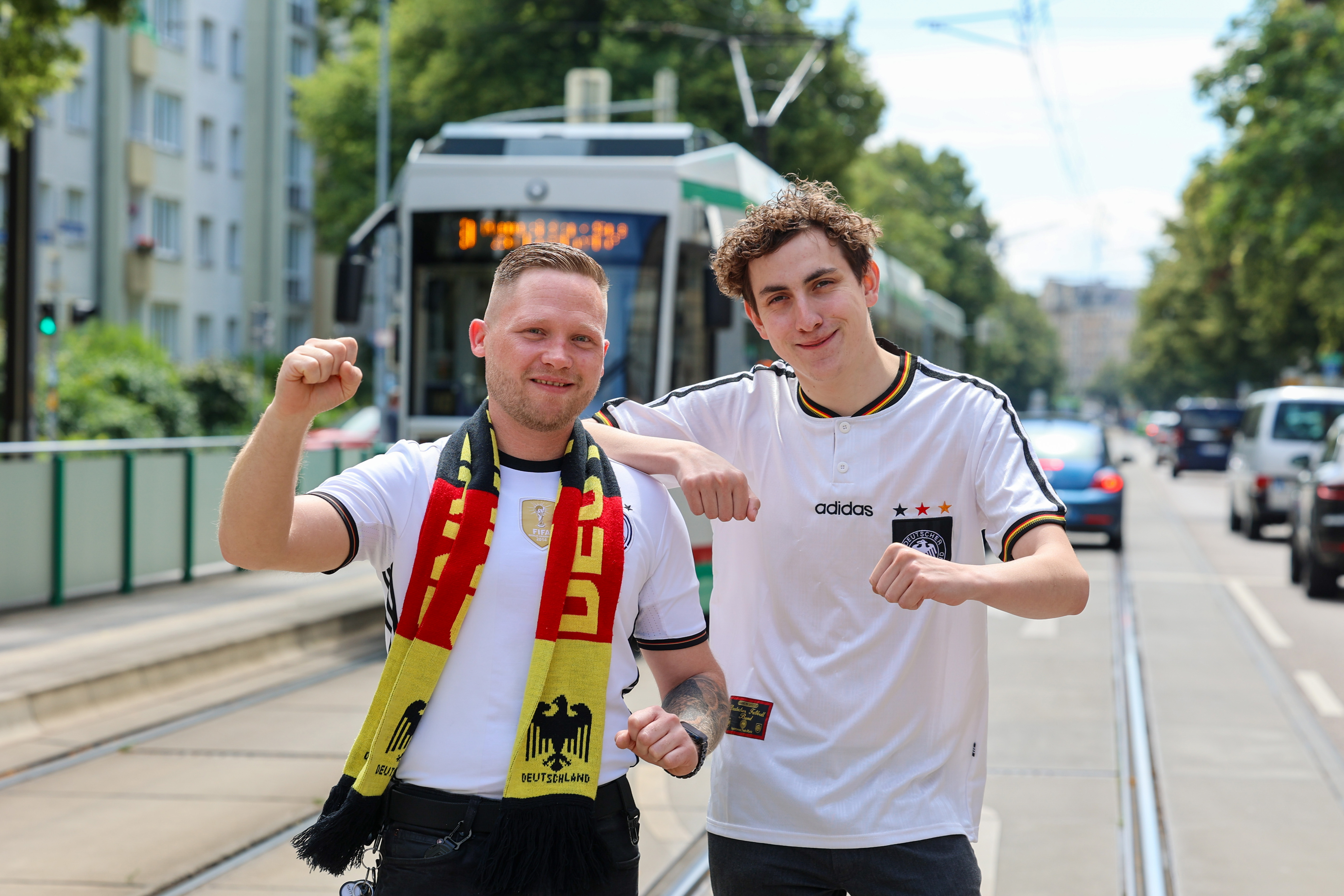 Zwei MVB Straßenbahnfahrer mit Deutschland Trikots vor einer Straßenbahn. Die Fahrer dürfen zur Heim Europameisterschaft das Trikot und nicht die Uniform tragen