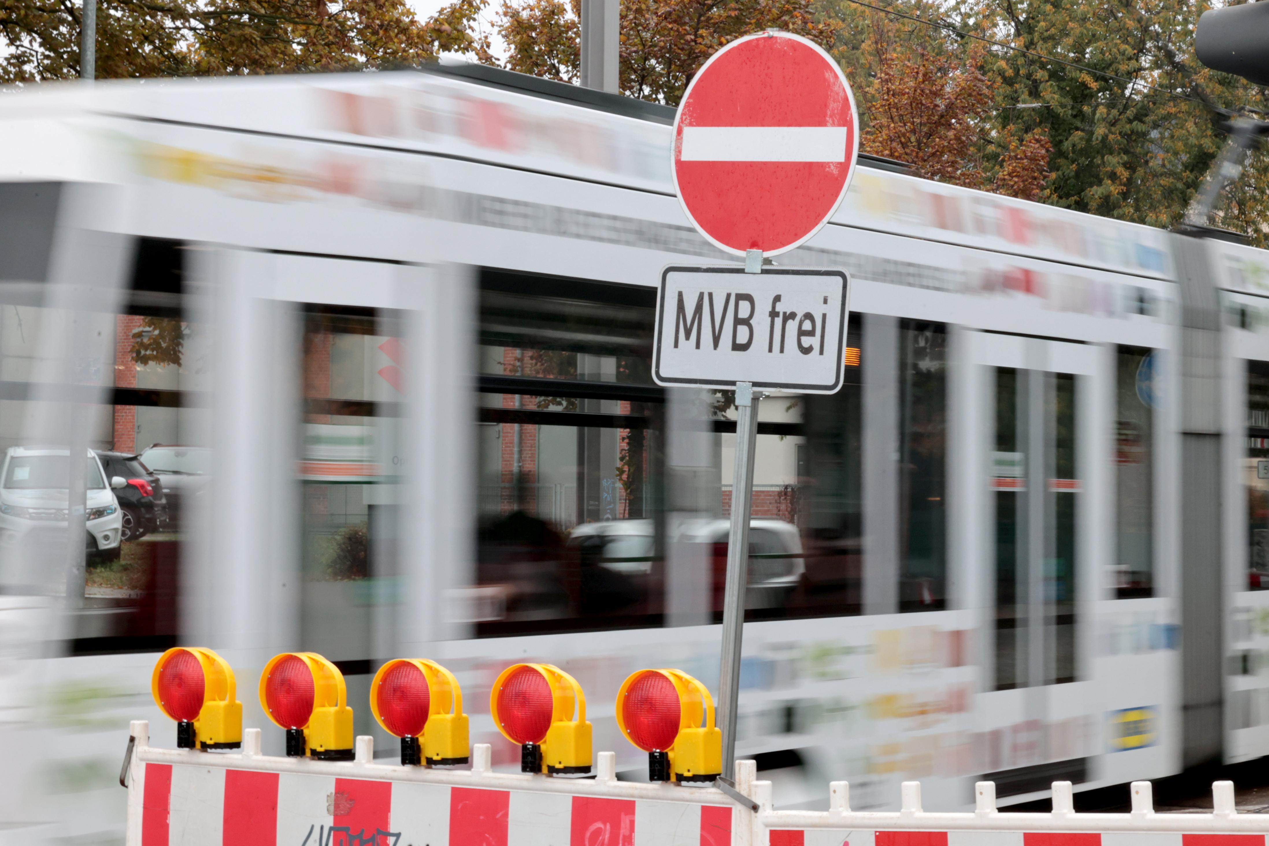 Verkehrsschild MVB frei mit bewegungsunscharfer Straßenbahn im Hintergrund.
