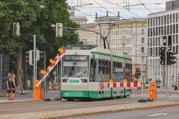 Straßenbahn der Linie 4 auf der Ernst-Reuter-Allee vor einer Baustellenschranke