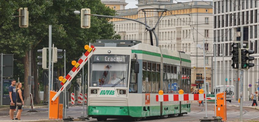 Straßenbahn der Linie 4 auf der Ernst-Reuter-Allee vor einer Baustellenschranke