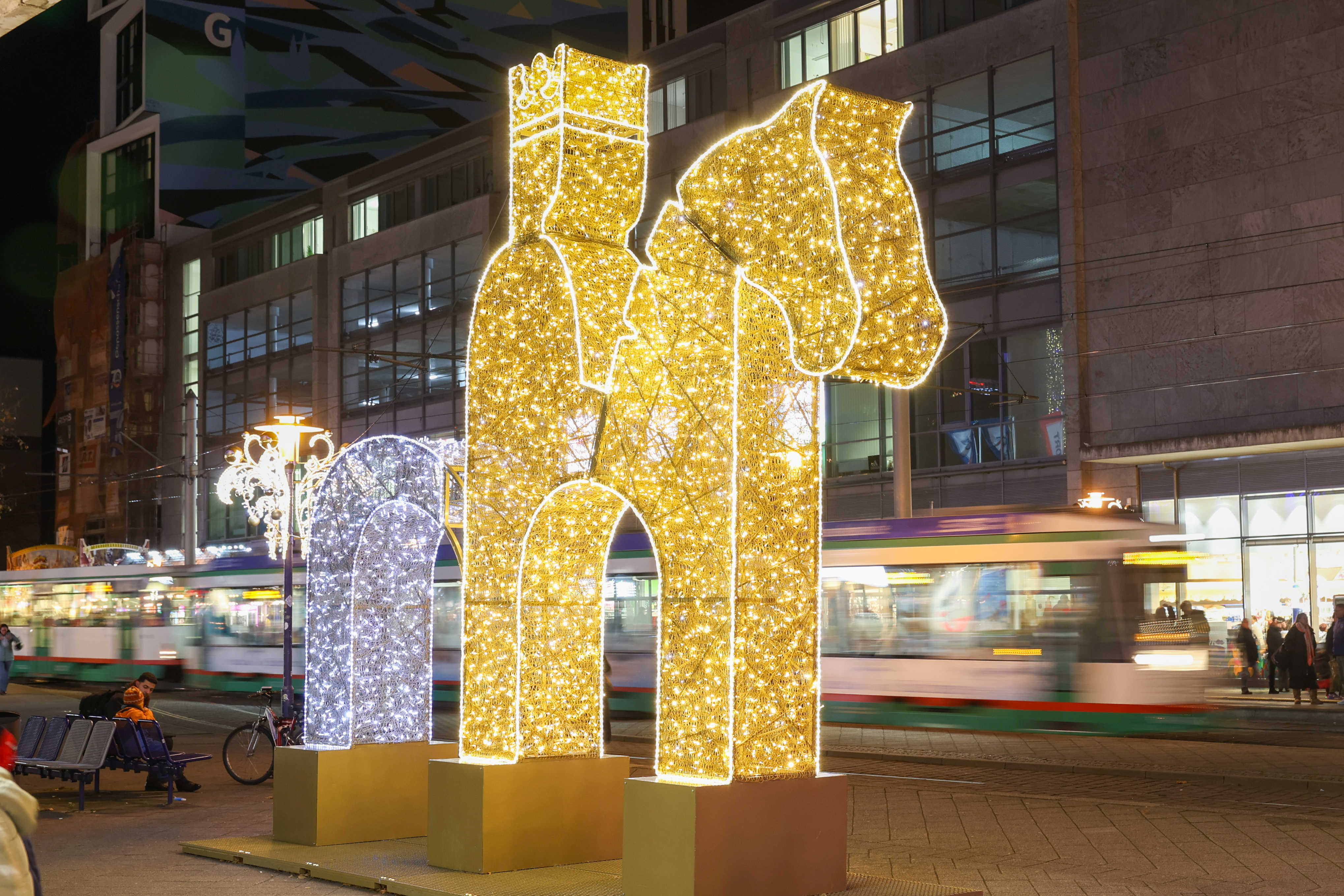 Lichtinstallation des Magdeburger Reiters mit einer fahrenden Straßenbahn im Hintergrund