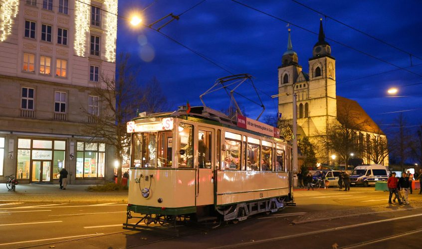 Ein alter Sonderwagen der Magdeburger Verkehrsbetriebe fährt über die weihnachtlich geschmückte Ernst-Reuther-Allee