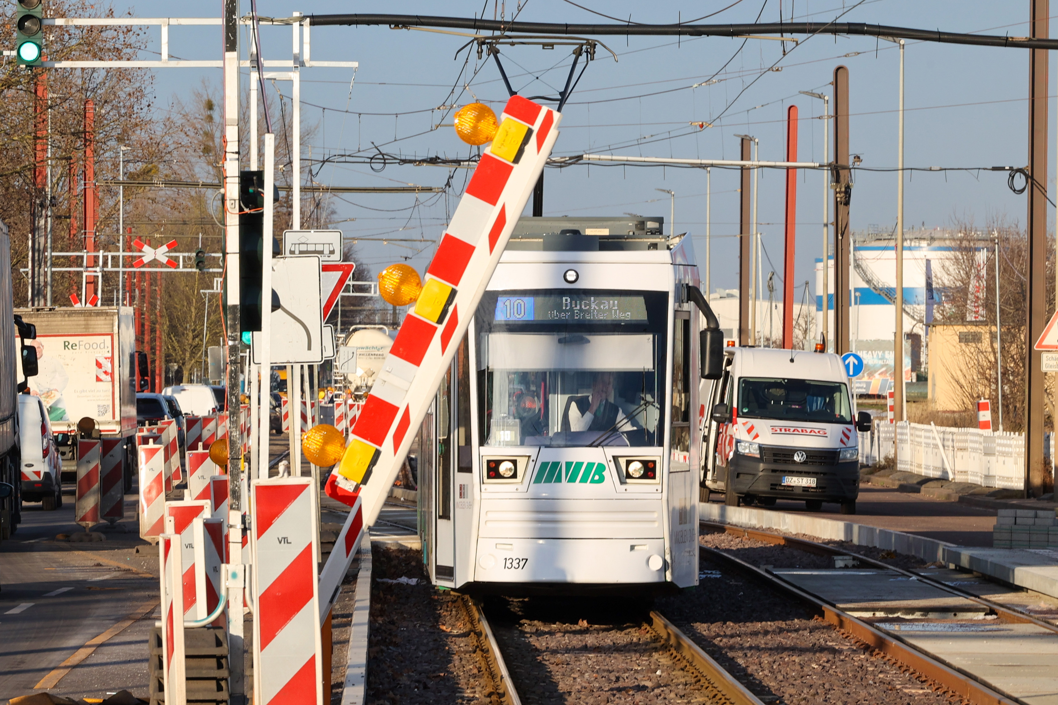 Straßenbahn der Linie 10 hinter einen halb geöffneten Baustellenschranke auf der MVB Strabag Baustelle August Bebel Damm.