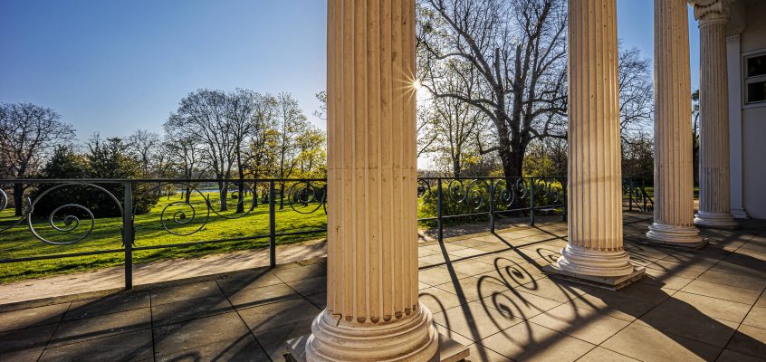 Blick aus dem Säulengang des Gesellschaftshauses auf den Klosterbergegarten und die Elbe.
