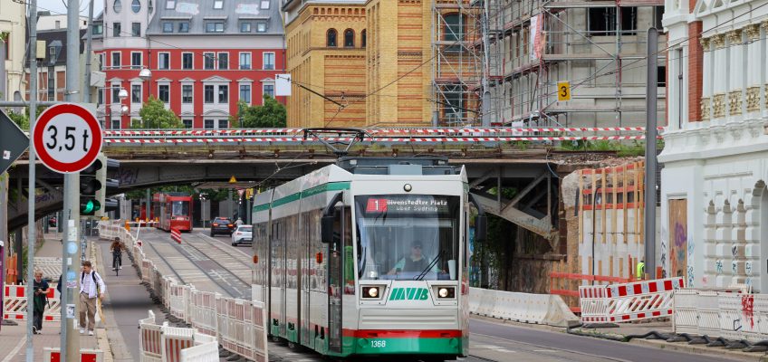 Straßenbahn fährt unterhalb der Eisenbahnbrücke in der Hallischen Straße.