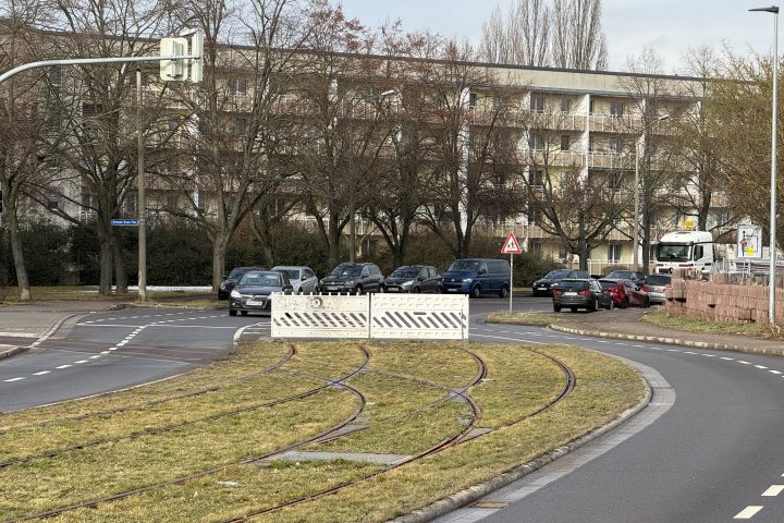 Blick in die Kritzmannstraße mit Straßenbahngleisen in der Straßenmitte. Am Bauende befindet sich eine Absperrung.