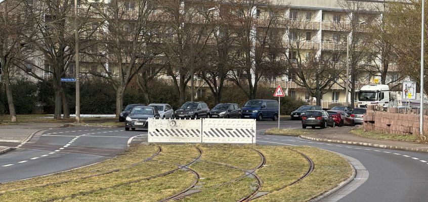 Blick in die Kritzmannstraße mit Straßenbahngleisen in der Straßenmitte. Am Bauende befindet sich eine Absperrung.