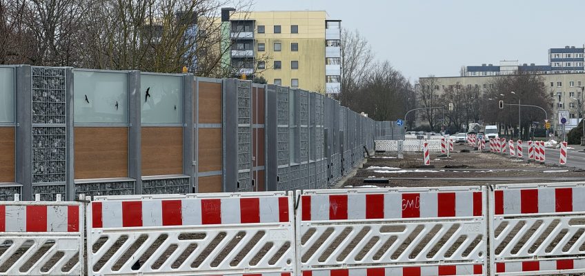 Blick auf das Baufeld im Burgstaller Weg. Im Vordergrund ein rot-weißer Absperrzaun.