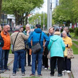 Teilnehmende eines Stadtrundgangs informieren sich am Breiten Weg über die Geschichte und Entwicklung des Nordabschnitts der Magdeburger Innenstadt.
