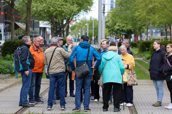 Teilnehmende eines Stadtrundgangs informieren sich am Breiten Weg über die Geschichte und Entwicklung des Nordabschnitts der Magdeburger Innenstadt.