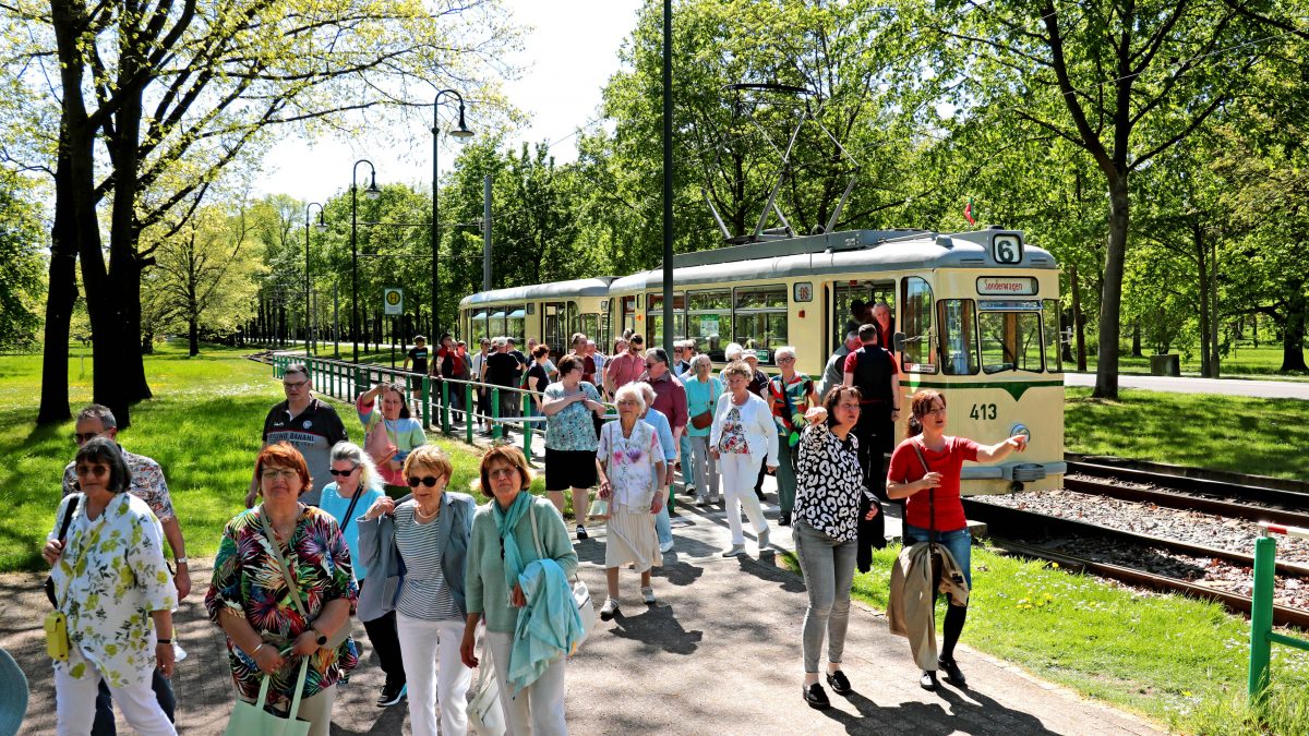 Historischer Gotha-Zug im Herrenkrug. Viele Fahrgäste im Vordergrund.