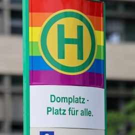 Haltestellenstele Domplatz in Regenbogenfarben.