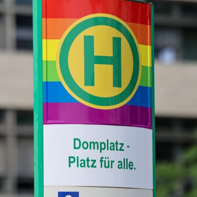 Haltestellenstele Domplatz in Regenbogenfarben.