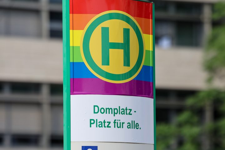 Haltestellenstele Domplatz in Regenbogenfarben.