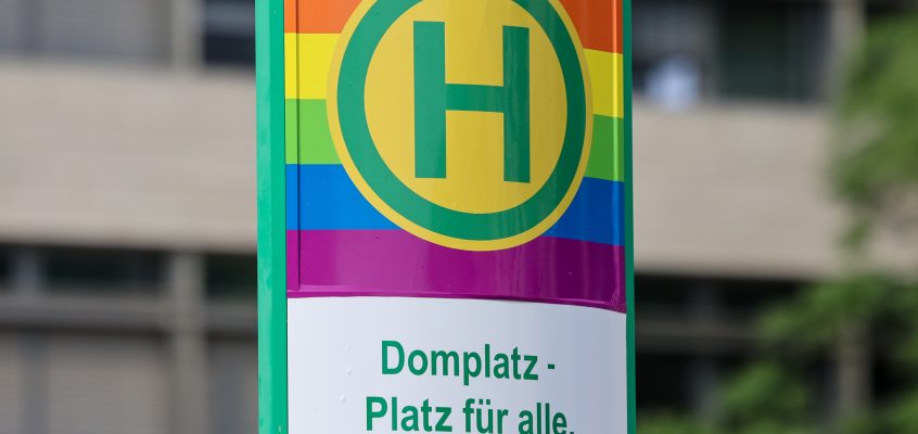Haltestellenstele Domplatz in Regenbogenfarben.