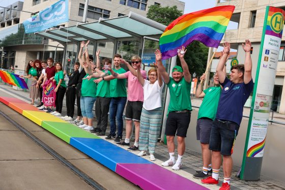 Bahnsteig mit Menschen in Regenbogenfarben.