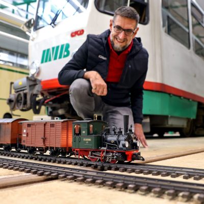 Modelleisenbahn im Museumsdepot vor einer großen Tatra-Straßenbahn